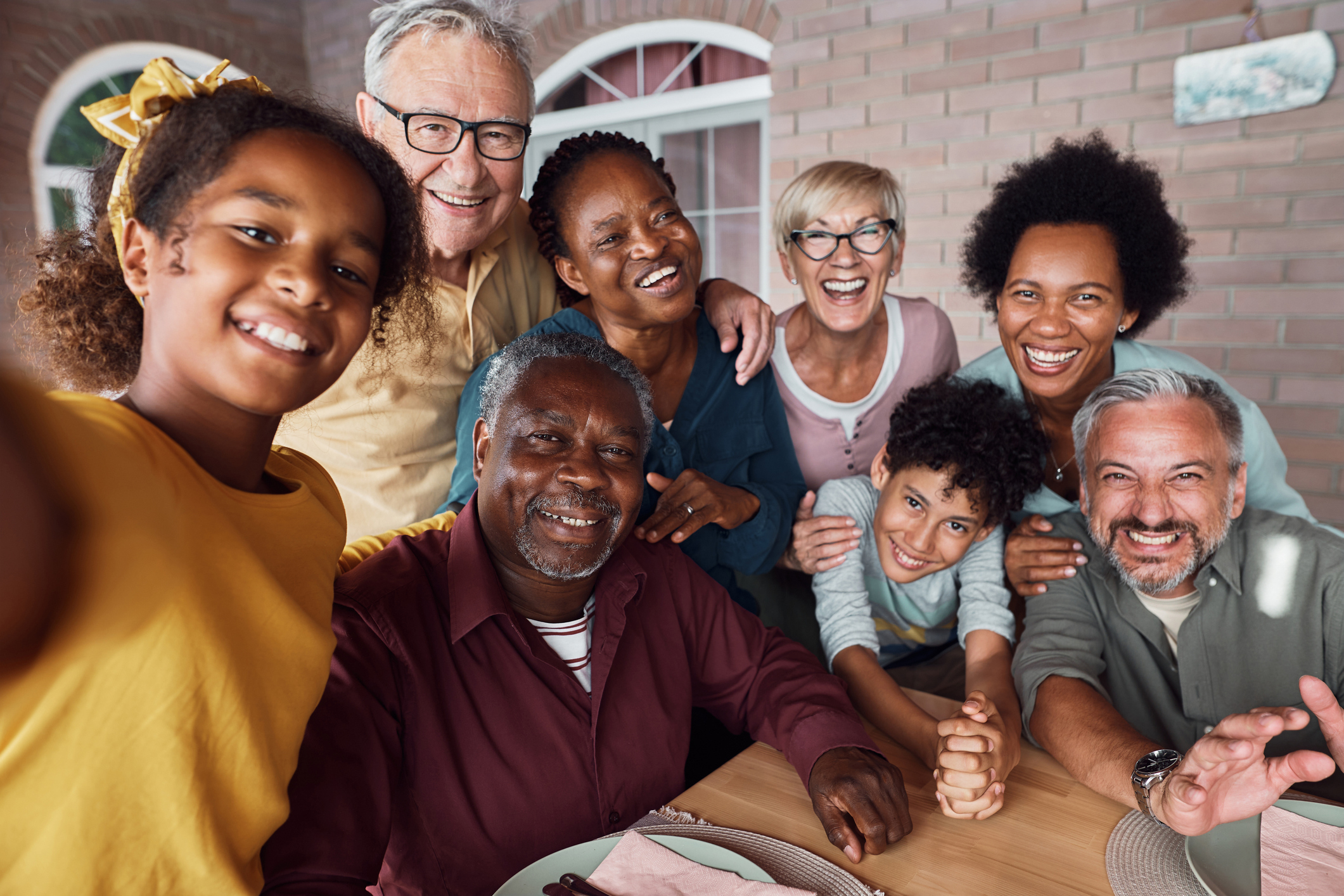A welcoming multigenerational group of Black and white family members smiling together
